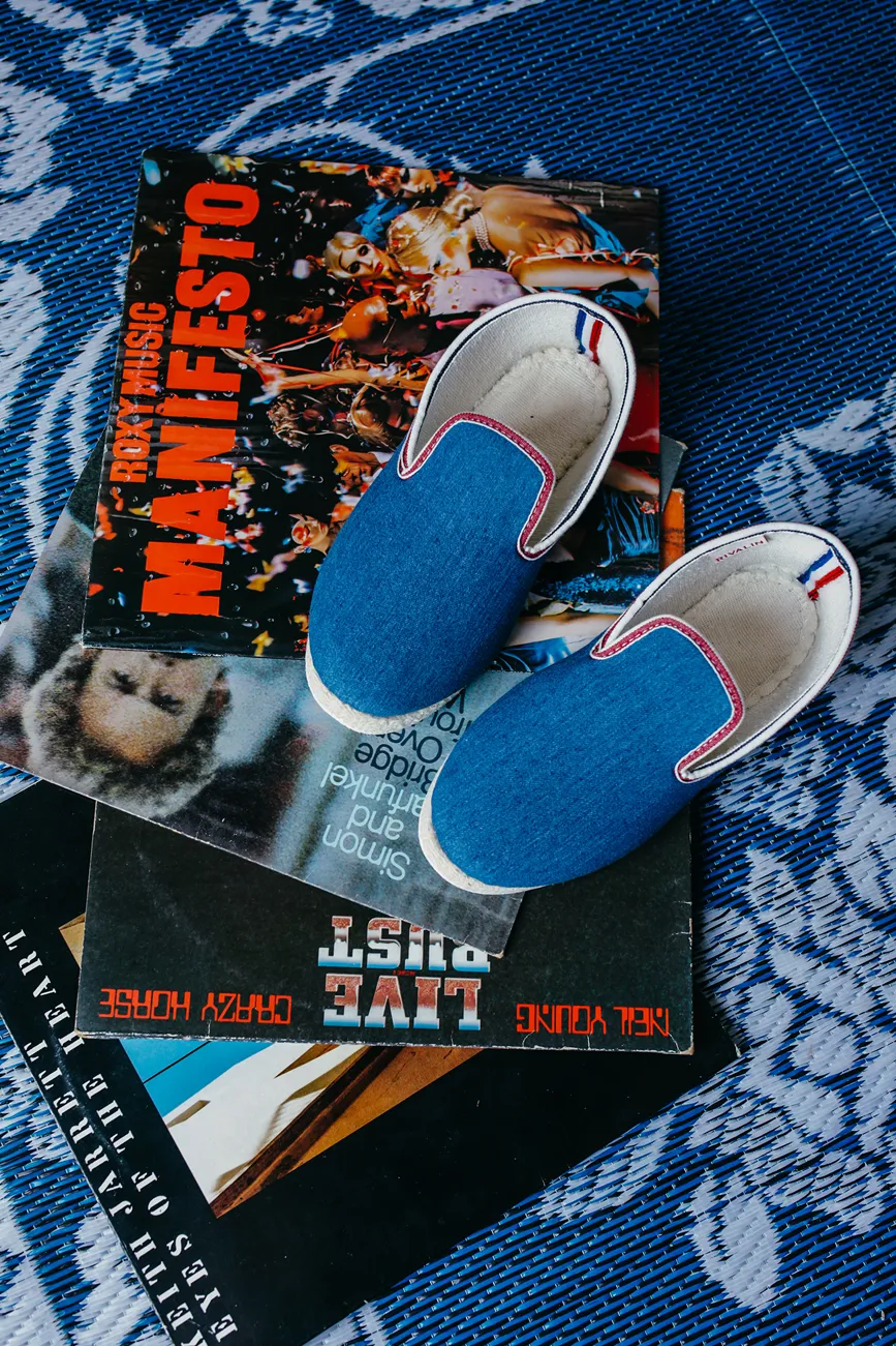 Pantoufles bleues Rivalin posées sur des vinyls