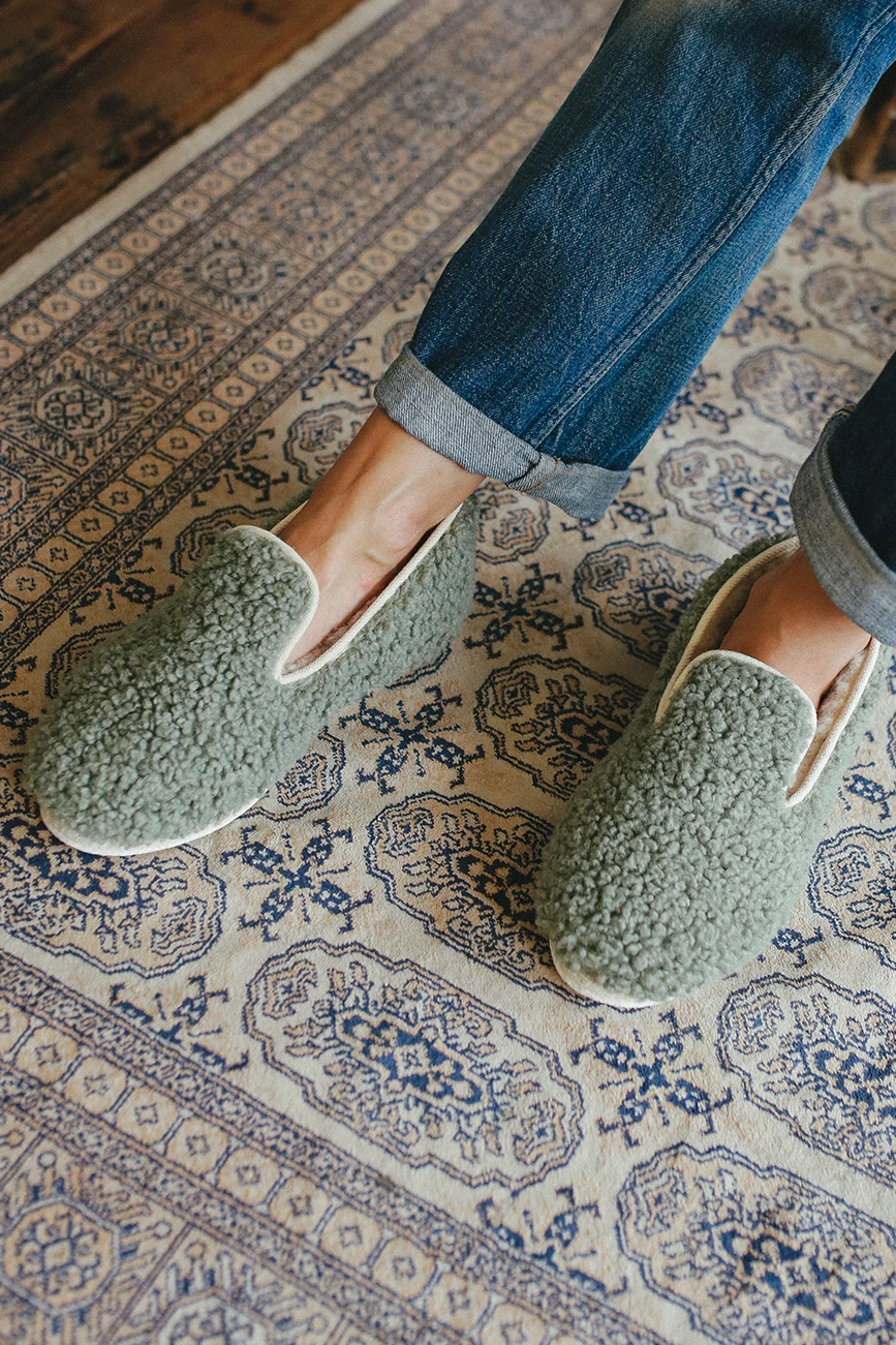 Chaussons verts sur tapis bleu et blanc